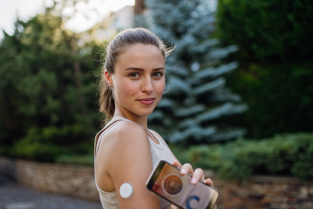 Young woman with continuous glucose monitor tracking wellness